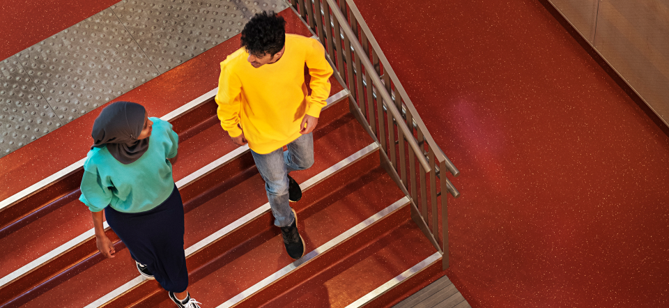 Young students walk down a staircase at OsloMet