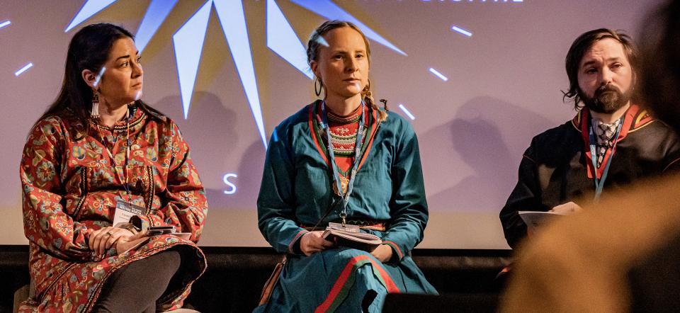 Three panelists on a stage. From left to right: Crystal Gail Fraser, Eva Marie Fjellheim and Mikkel Berg-Norlie.