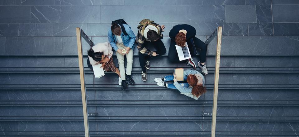 Young people sitting in stairs at school