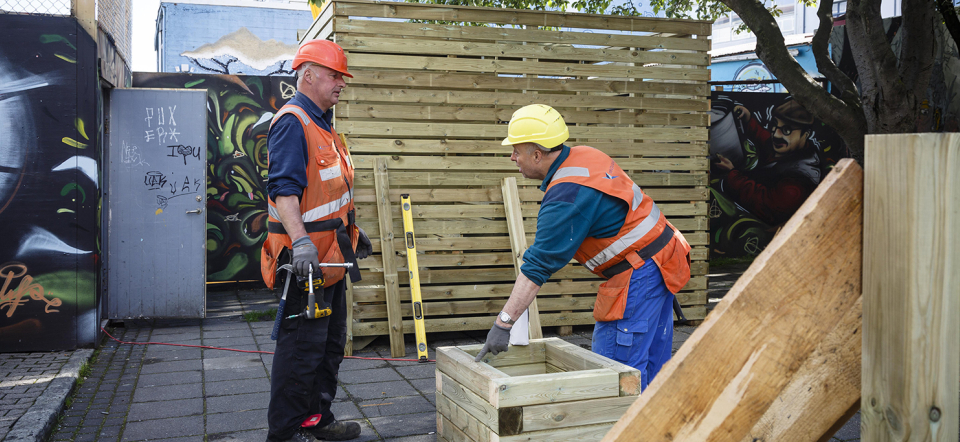 Two senior carpenters working outside