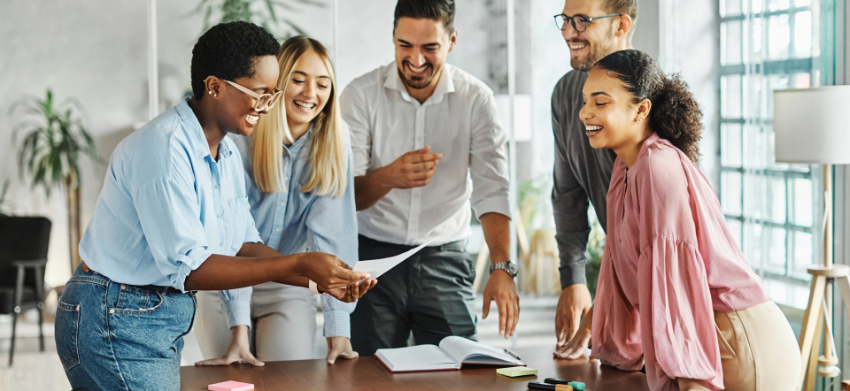 Fem unge mennesker taler sammen hen over et bord.