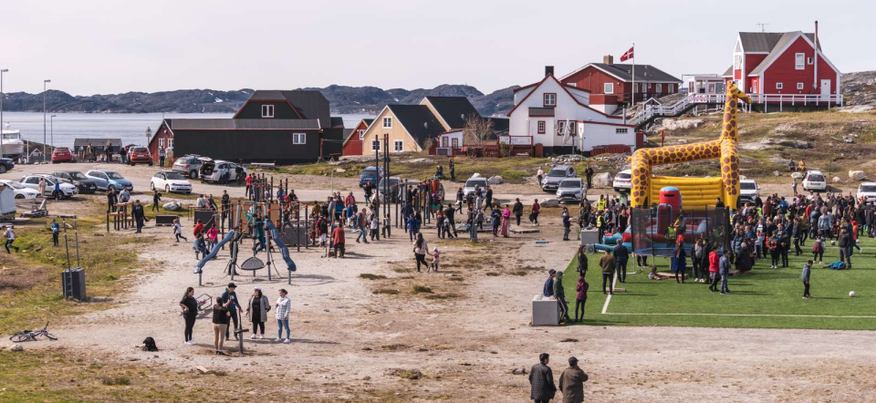 Mennesker er udenfor i Nuuk en sommerdag.