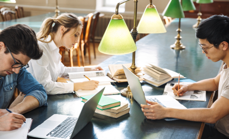 Three people studying in a library