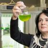 Yagut Allahverdiyeva-Rinne holding a glass flask with a green substance._Photo by Hanna Oksanen, University of Turku