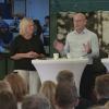 Paneldeltakere på scenen foran publikum