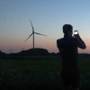 Man takes a picture of windmills at night